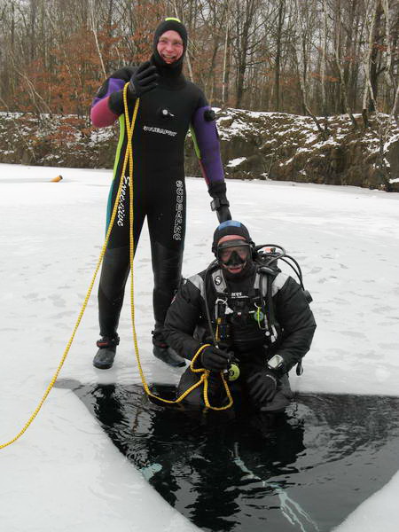 Taucher steigt ins Eisloch.